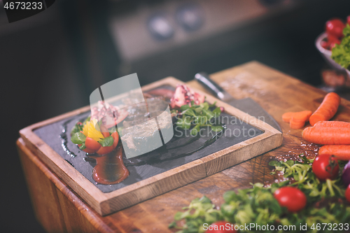 Image of Juicy slices of grilled steak on wooden board