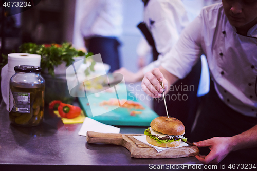 Image of chef finishing burger