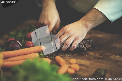 Image of closeup of Chef hands preparing beef steak