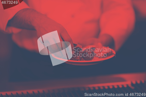 Image of chef hands cooking grilled salmon fish