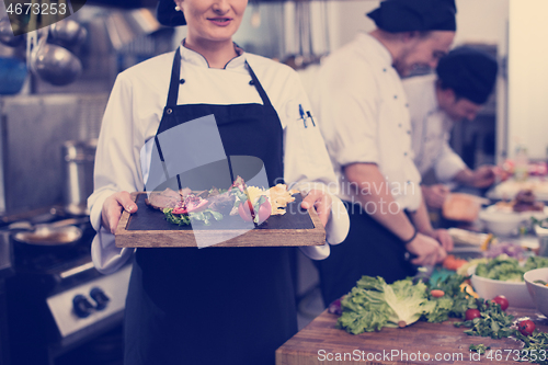 Image of female Chef holding beef steak plate