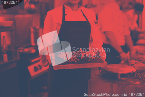 Image of female Chef holding beef steak plate