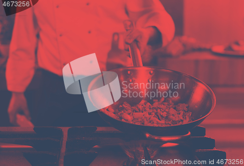 Image of chef flipping vegetables in wok