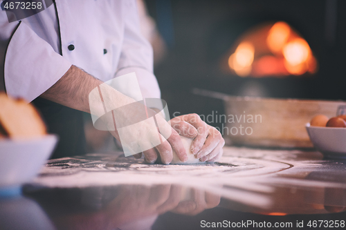 Image of chef hands preparing dough for pizza