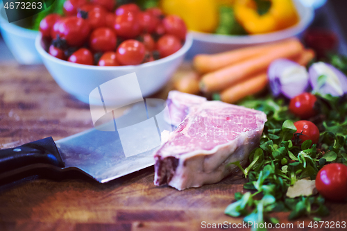 Image of Juicy slice of raw steak on wooden table