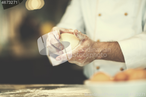 Image of chef hands preparing dough for pizza