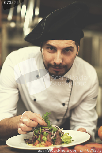 Image of cook chef decorating garnishing prepared meal