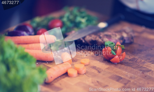 Image of Juicy slices of grilled steak on wooden board