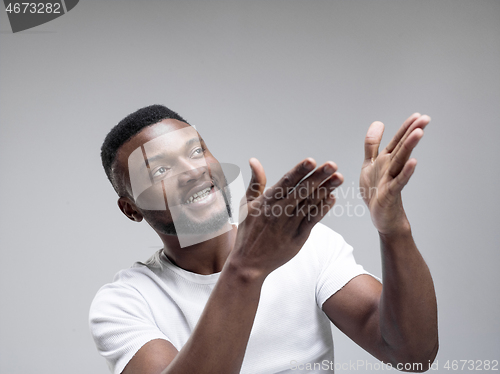 Image of African american man excited about watching tv.