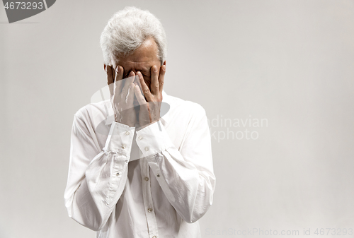 Image of Portrait of upset old man rubbing his eye while crying.