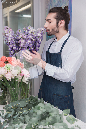 Image of Small business. Male florist in flower shop. Floral design studio, making decorations and arrangements.