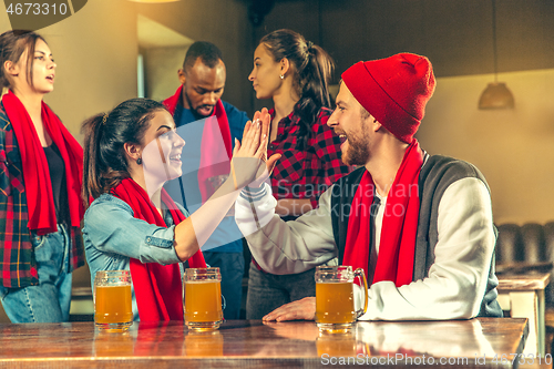 Image of Sport, people, leisure, friendship and entertainment concept - happy football fans or male friends drinking beer and celebrating victory at bar or pub