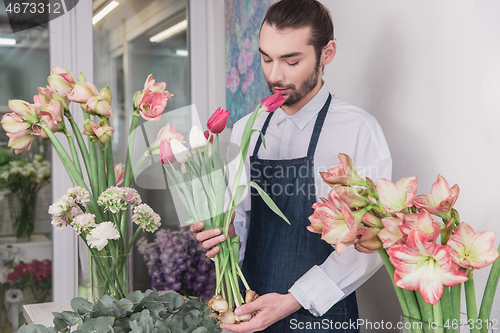 Image of Small business. Male florist in flower shop. Floral design studio, making decorations and arrangements.