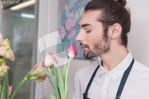 Image of Small business. Male florist in flower shop. Floral design studio, making decorations and arrangements.