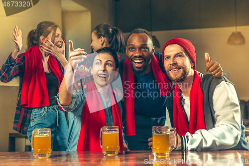 Image of Sport, people, leisure, friendship and entertainment concept - happy football fans or male friends drinking beer and celebrating victory at bar or pub