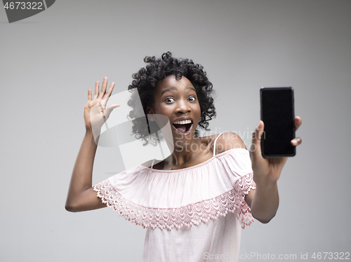 Image of Portrait of a confident casual afro girl showing blank screen mobile phone