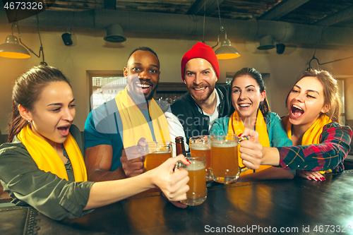 Image of Sport, people, leisure, friendship and entertainment concept - happy football fans or male friends drinking beer and celebrating victory at bar or pub