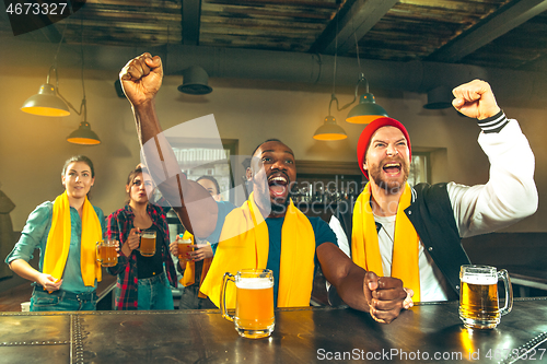 Image of Sport, people, leisure, friendship and entertainment concept - happy football fans or male friends drinking beer and celebrating victory at bar or pub