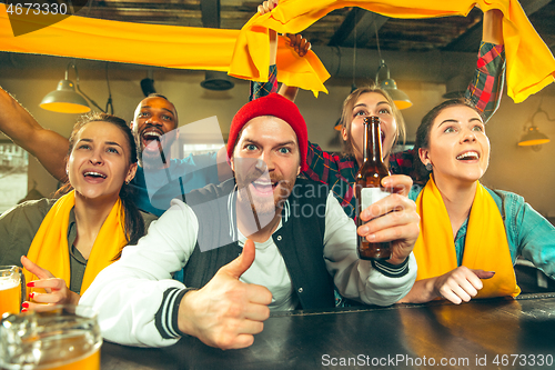 Image of Sport, people, leisure, friendship and entertainment concept - happy football fans or male friends drinking beer and celebrating victory at bar or pub