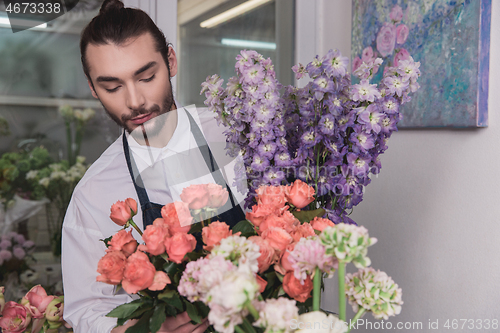 Image of Small business. Male florist in flower shop. Floral design studio, making decorations and arrangements.