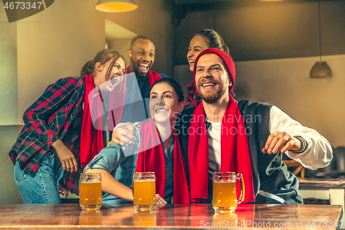 Image of Sport, people, leisure, friendship and entertainment concept - happy football fans or male friends drinking beer and celebrating victory at bar or pub