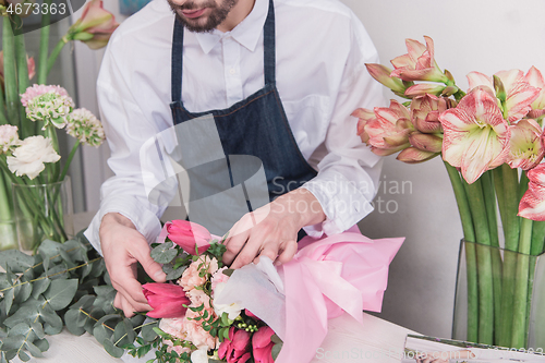 Image of Small business. Male florist in flower shop. Floral design studio, making decorations and arrangements.