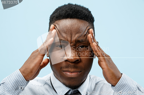 Image of Man having headache. Isolated over blue background.