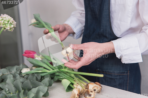 Image of Small business. Male florist in flower shop. Floral design studio, making decorations and arrangements.