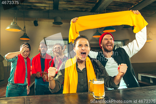 Image of Sport, people, leisure, friendship and entertainment concept - happy football fans or male friends drinking beer and celebrating victory at bar or pub