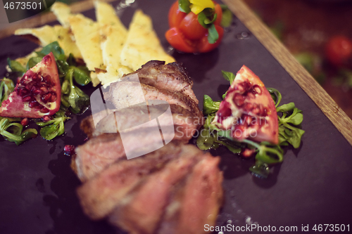 Image of Juicy slices of grilled steak on wooden board