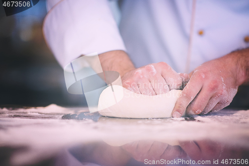 Image of chef hands preparing dough for pizza