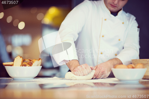 Image of young chef preparing dough for pizza