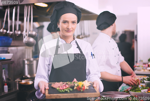 Image of female Chef holding beef steak plate