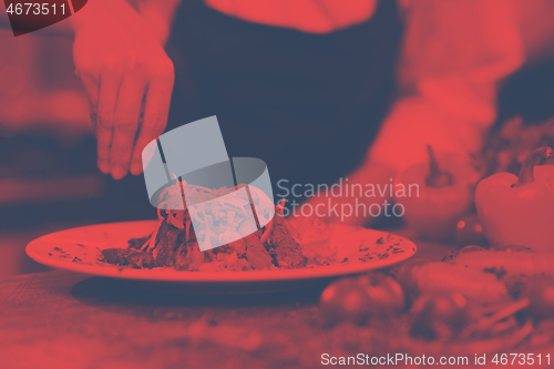 Image of cook chef decorating garnishing prepared meal