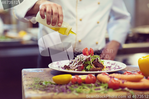 Image of Chef finishing steak meat plate