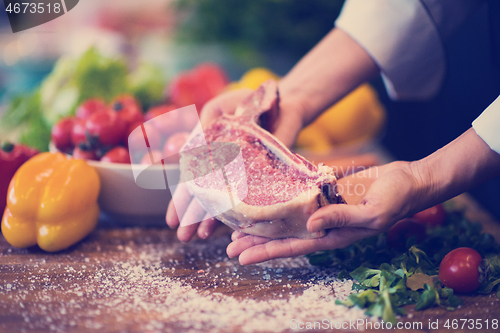 Image of Chef holding juicy slice of raw steak