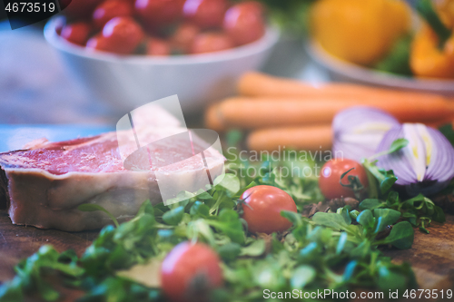 Image of Juicy slice of raw steak on wooden table