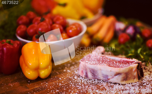 Image of Juicy slice of raw steak on wooden table