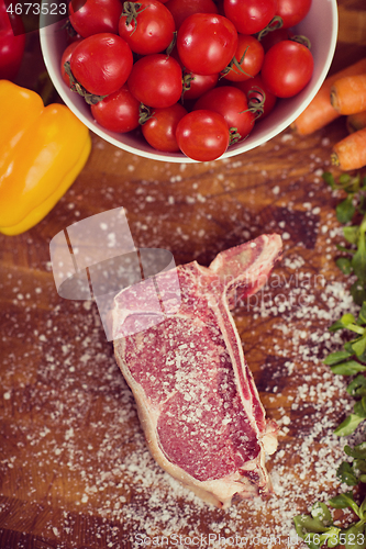 Image of top view of raw steak on wooden table