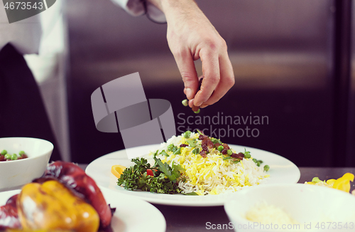 Image of Chef hands serving vegetable risotto