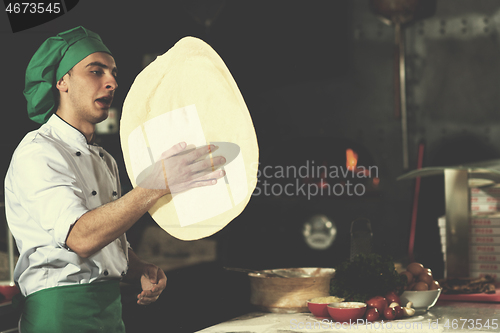 Image of chef throwing up pizza dough