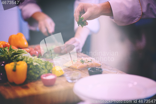 Image of Chef hands preparing marinated Salmon fish