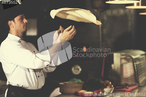 Image of chef throwing up pizza dough