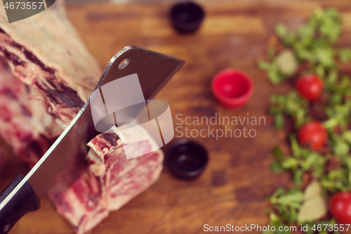 Image of chef cutting big piece of beef