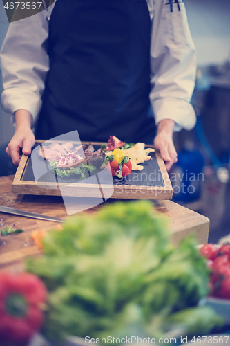 Image of female Chef holding beef steak plate