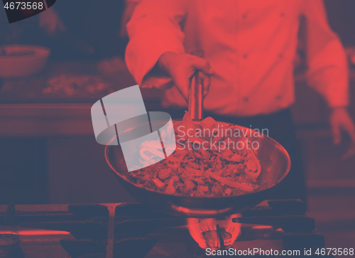 Image of chef flipping vegetables in wok