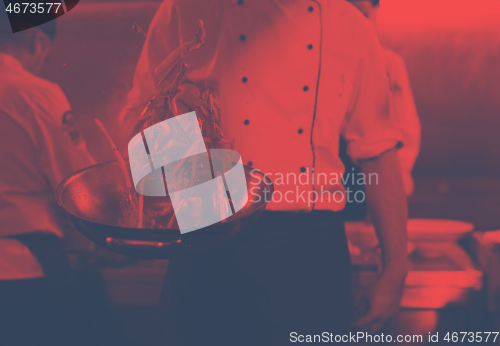 Image of chef flipping vegetables in wok