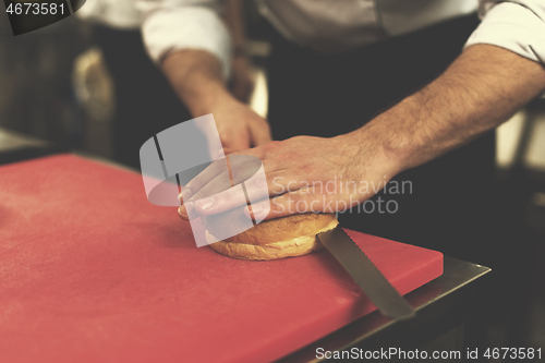 Image of chef hands cutting rolls for burger