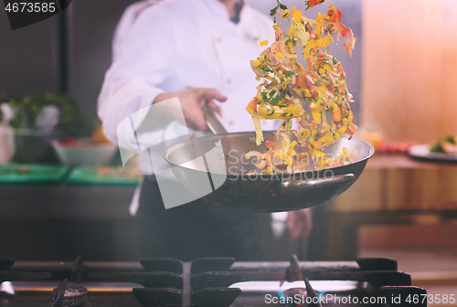 Image of chef flipping vegetables in wok