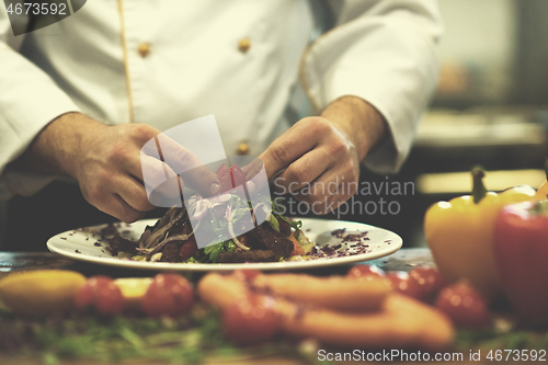 Image of cook chef decorating garnishing prepared meal